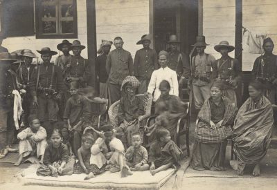 1907 - 18x13cm A 1st lieutenant of the KNIL (back row bareheaded) with a unit trooper with relatives Si Singamangaraja XII in Pasanggrahan to Siborongborong 02.jpg